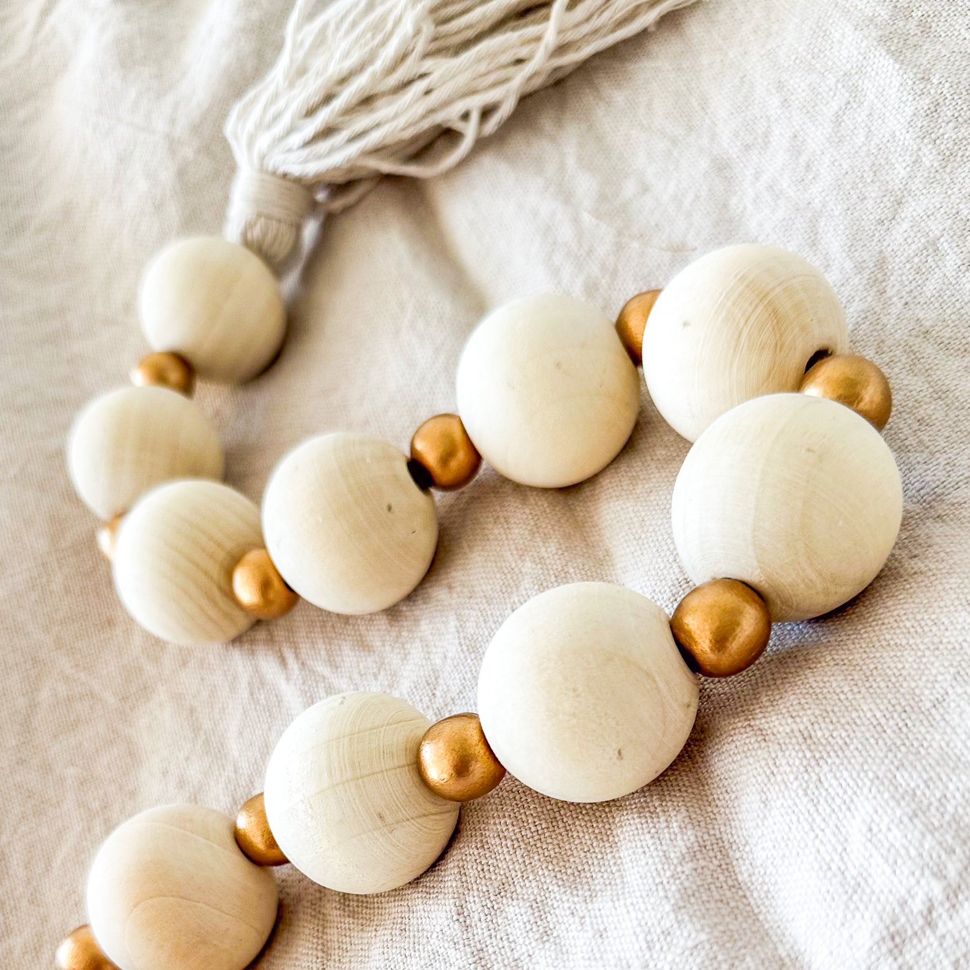 Adorno cuentas madera y doradas con borlas Adorno Frank Home Chile