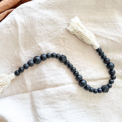 Adorno cuentas madera negras con borlas blancas Adorno Frank Home Chile