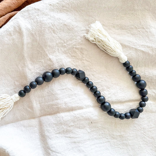 Adorno cuentas madera negras con borlas blancas Adorno Frank Home Chile