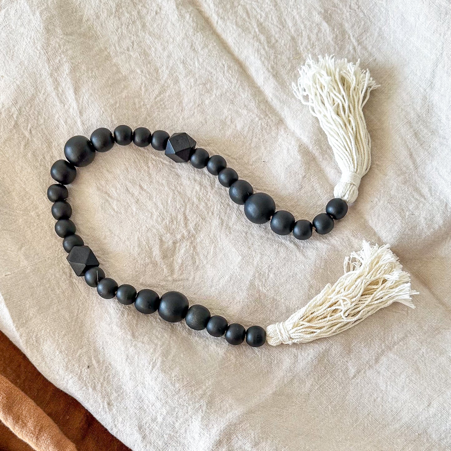 Adorno cuentas madera negras con borlas blancas Adorno Frank Home Chile