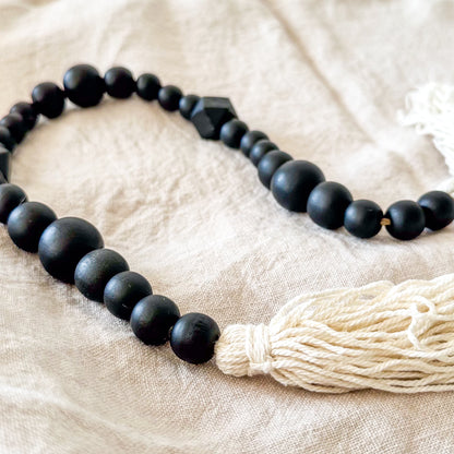 Adorno cuentas madera negras con borlas blancas Adorno Frank Home Chile